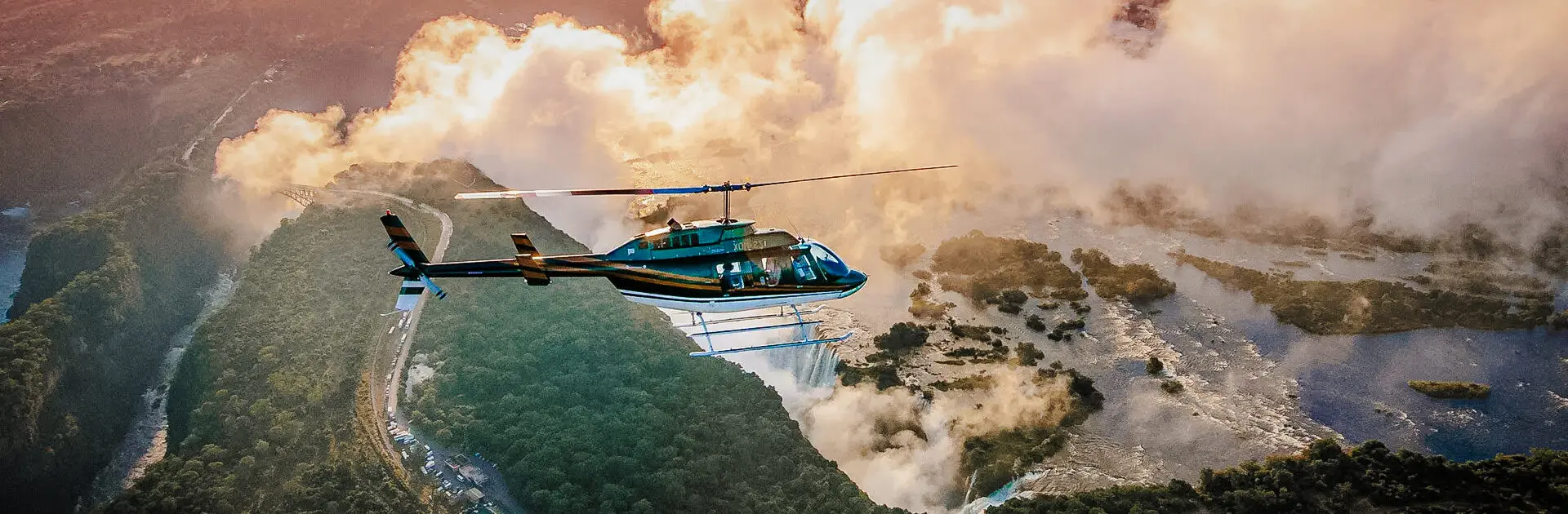 A helicopter flies over the mist cloud above Victoria Falls in Zimbabwe | Go2Africa